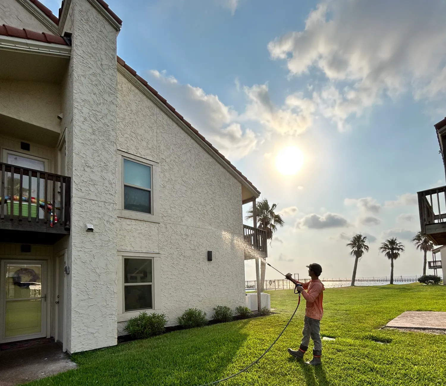 Soft washing a coastal condo at sunset